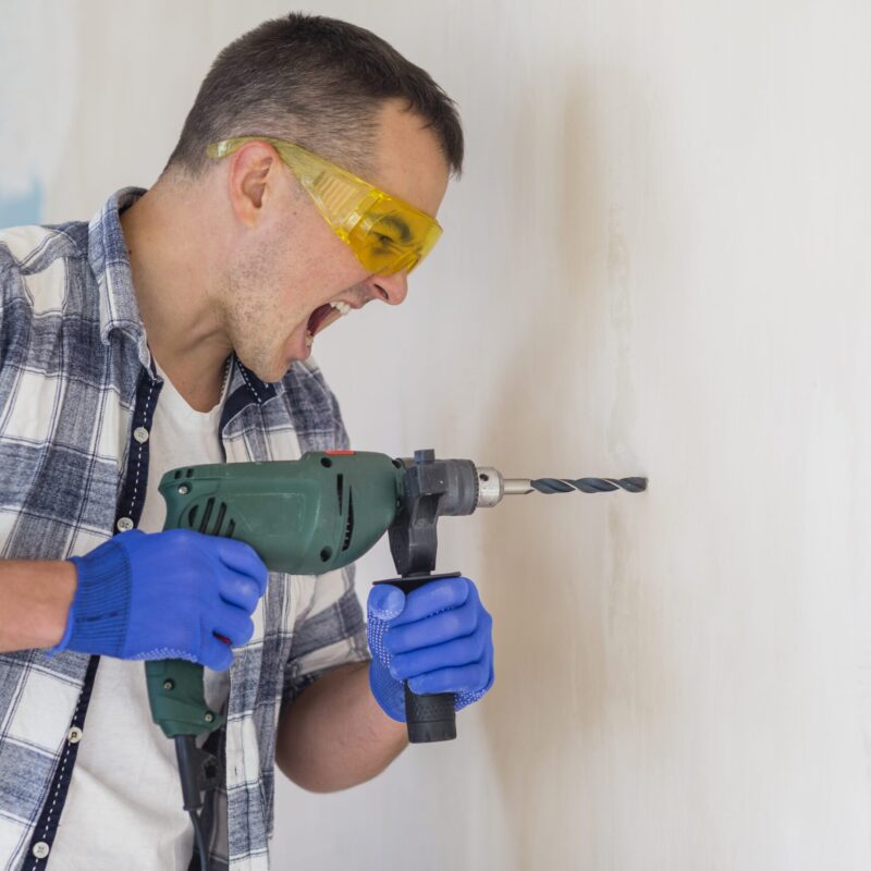 Confident man using a drill.